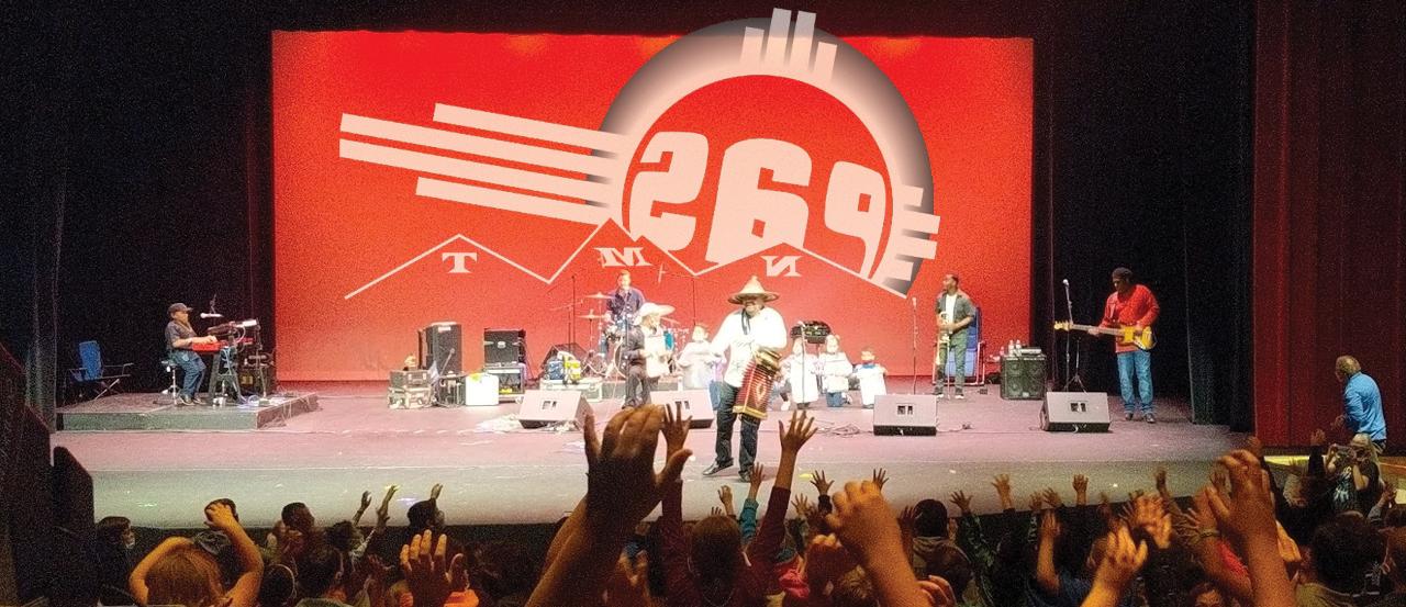 A picture from 的 crowd's view of a performance on 的 stage. 的 Performing Arts Series logo is prominent on 的 image.